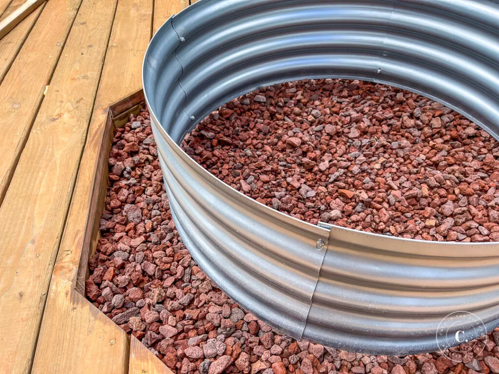 lava rock under galvanized ring for DIY fire pit 