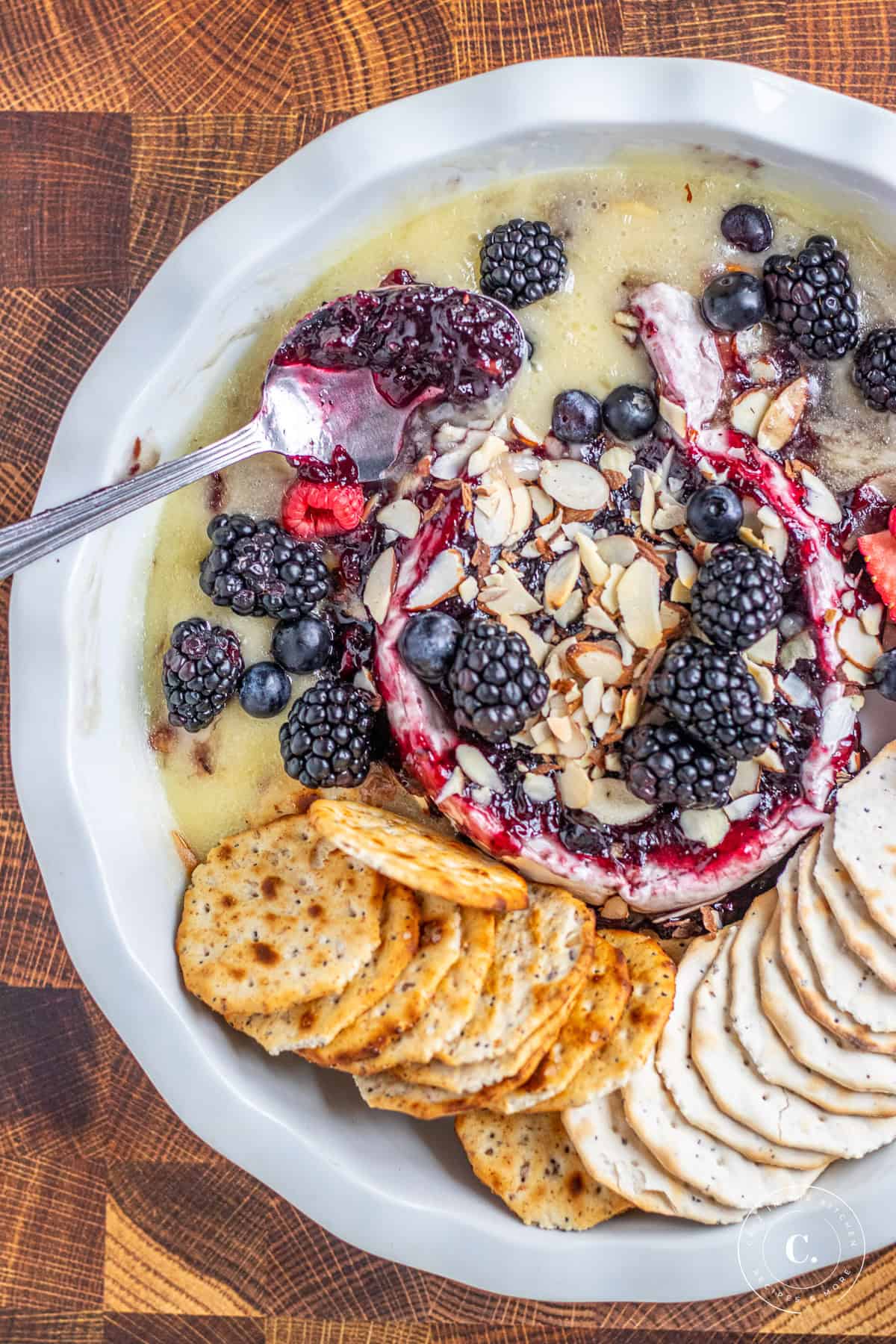 Baked Brie with Berry Jam with spoon and crackers